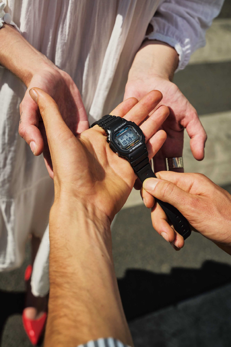 在户外激动时刻手持 G-SHOCK 的人。