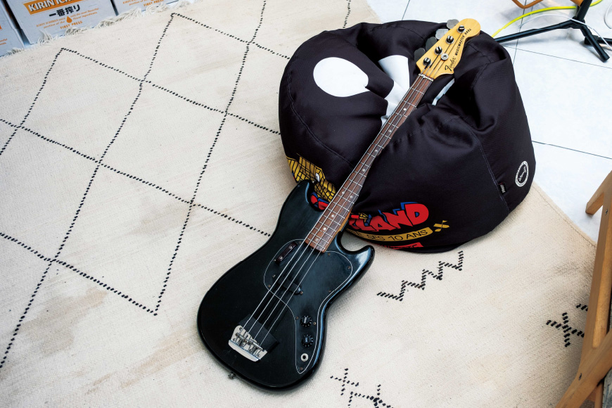 放在地板上的黑色吉他特写。