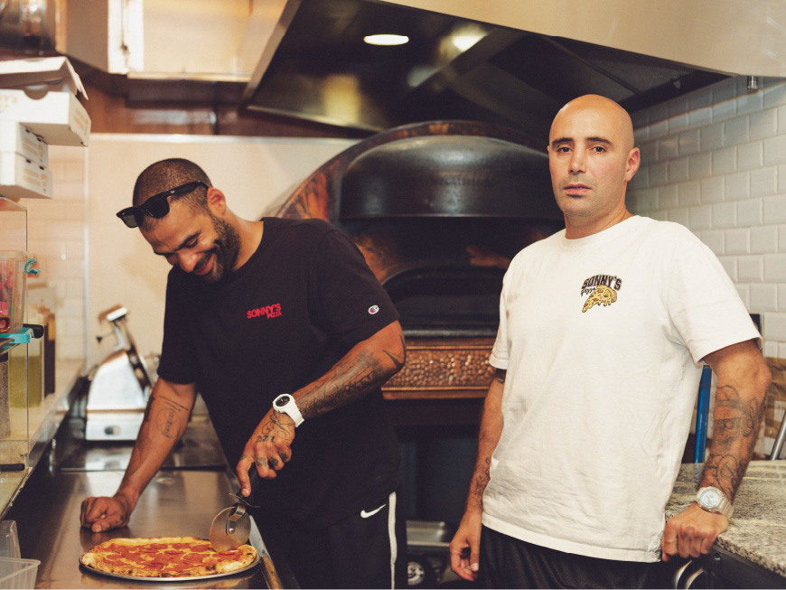 这是一张厨师在巴黎 Sonny's Pizza 厨房内准备披萨的照片。