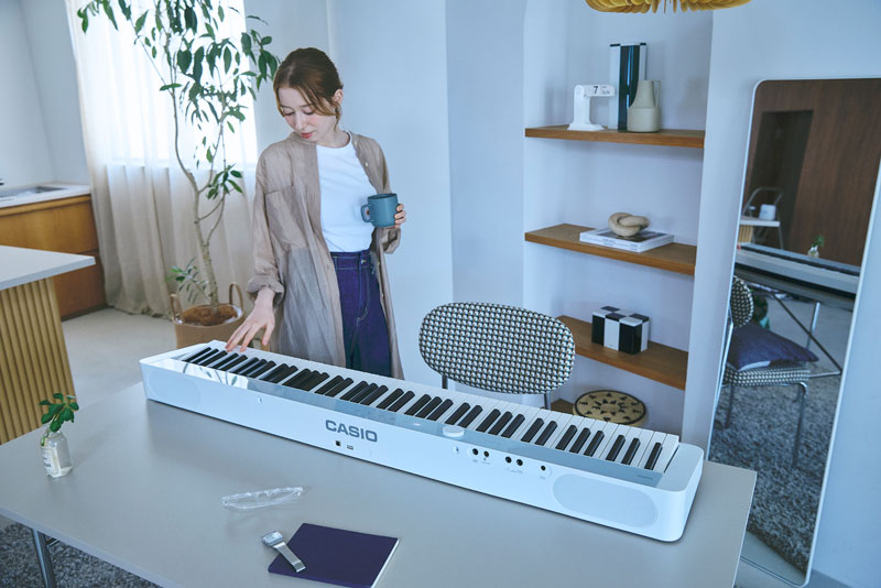 一个人站在钢琴附近并把手放在钢琴上的图像